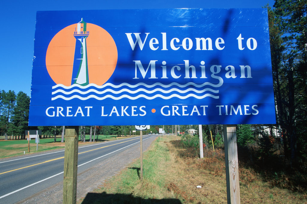 A sign that says welcome to michigan great lakes and great times.